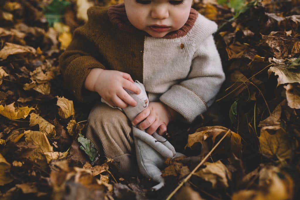 A boy listening to rustling leaves