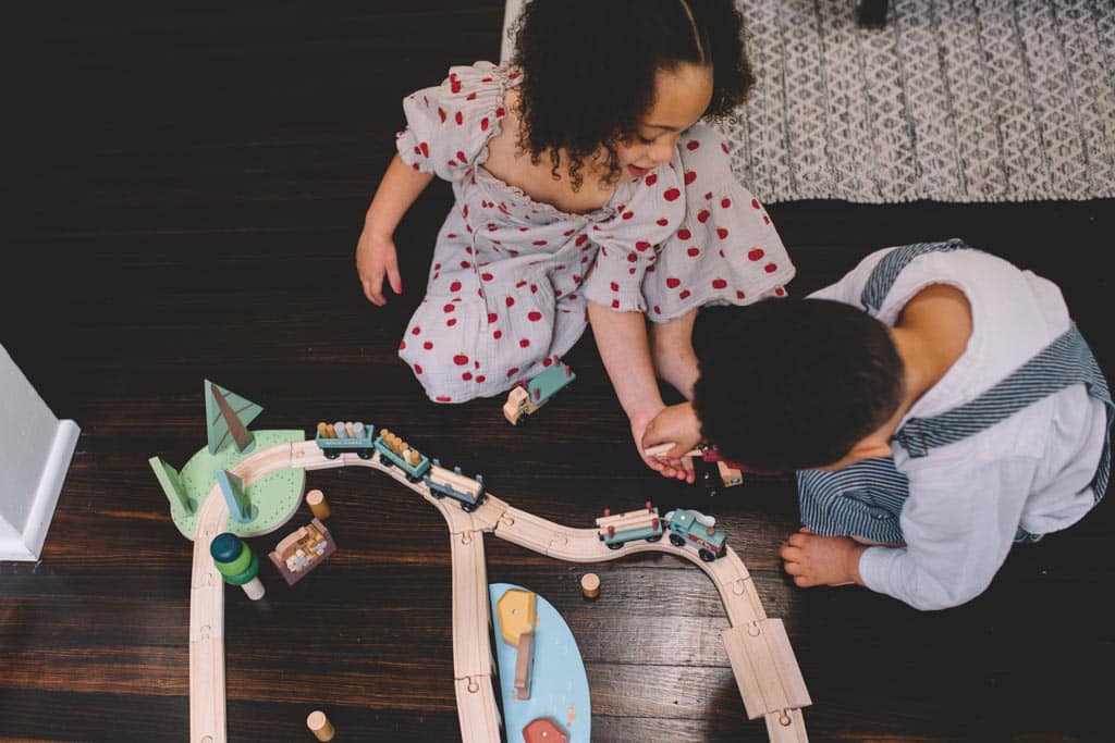 Children playing with a wooden train set