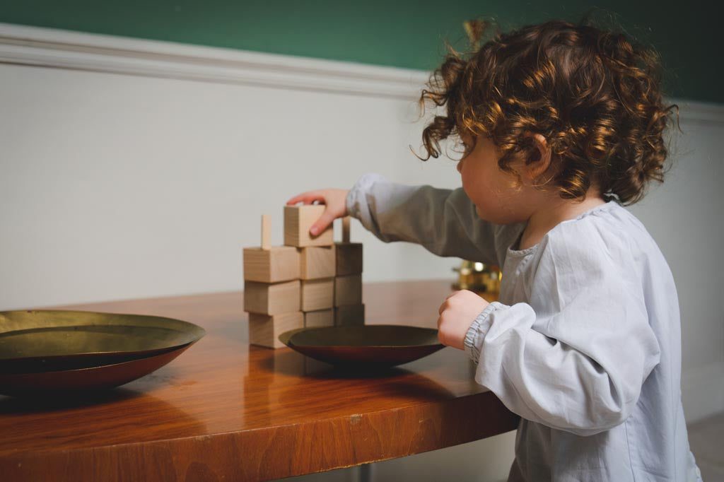 A toddler building a tower of blocks and learning to overcome challenges