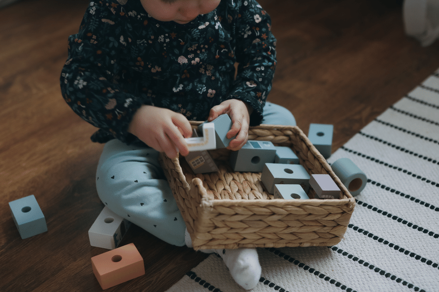 A toddler exploring a box of blocks